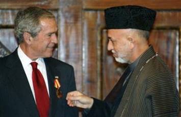 U.S. President George W. Bush receives a medal from Afghan President ...